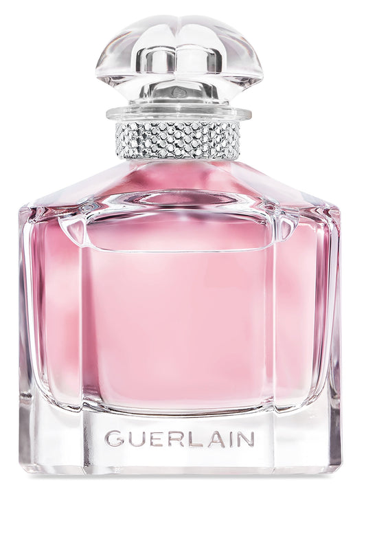 Guerlain perfume bottle with a faceted clear glass body filled with pink liquid, a silver rhinestone-embellished neck, and a clear sculptural cap on a white background.