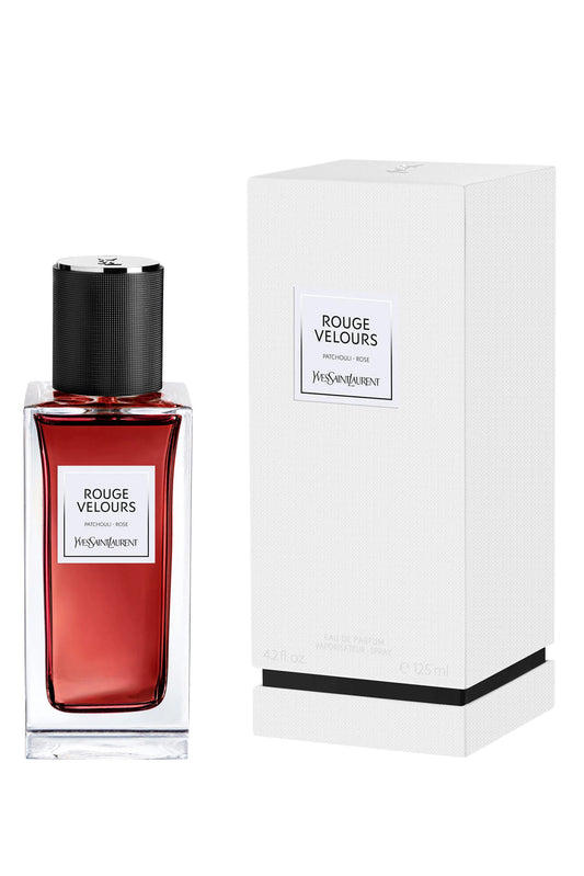 Red perfume bottle with black cap and white label next to its packaging box on a white background