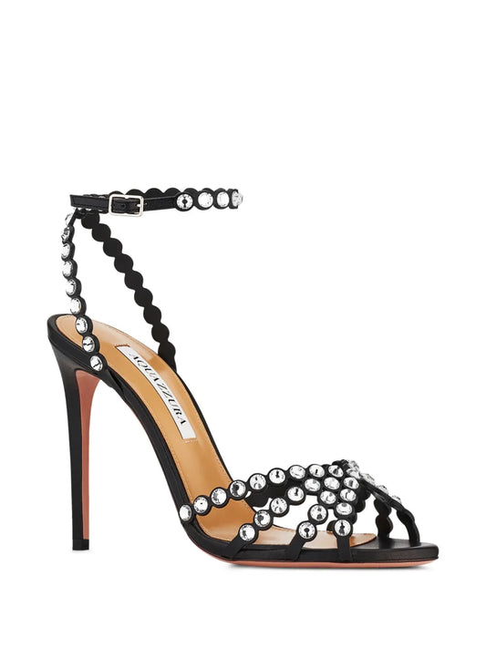 Black high-heeled sandal with pearl embellishments on a white background