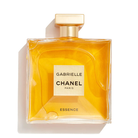 Chanel Gabrielle Essence perfume bottle with a square shape, filled with golden-yellow liquid and featuring a gold cap, set against a plain white background with a soft shadow.