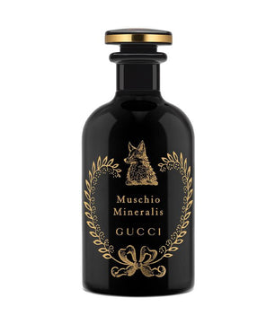 Black Gucci perfume bottle with gold accents on a white background