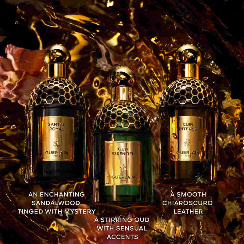 Three Guerlain perfume bottles with descriptive text on a dark, textured background.