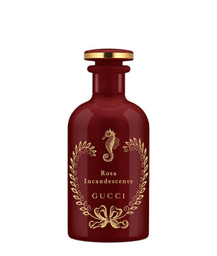 Gucci Rosa Incandescente perfume bottle in deep burgundy glass with gold foil detailing, a seahorse emblem, and a gold cap, shown on a plain white background.