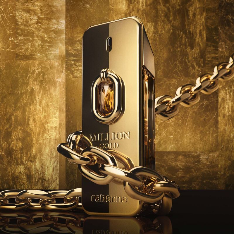 Gold and black perfume bottle with chain against a gold background