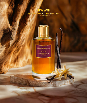 Mancera Xplific Vanilla perfume bottle with vanilla beans and flowers on a wooden surface.