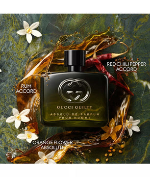 Gucci Guilty perfume bottle with floral and chili pepper elements on a dark background