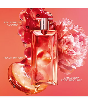 A perfume bottle labeled ROSE ORPUR with scent notes Red Berries Accord and Damascena Rose Absolute, styled with red berries, a peach heart, and a pink flower on a coral background.
