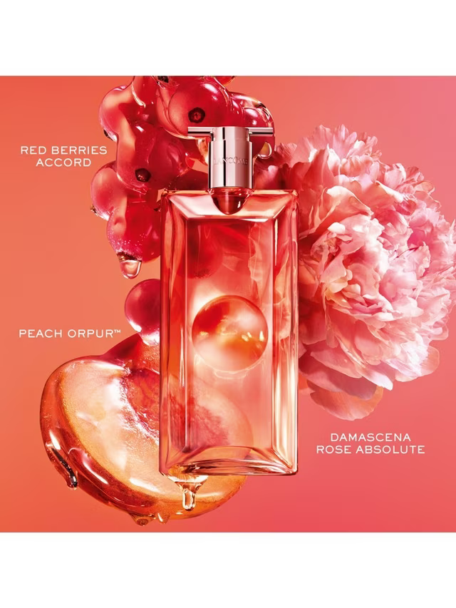 A perfume bottle labeled ROSE ORPUR with scent notes Red Berries Accord and Damascena Rose Absolute, styled with red berries, a peach heart, and a pink flower on a coral background.