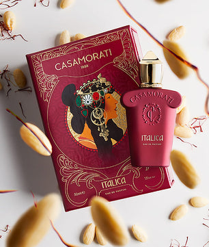 Casamorati Italica perfume bottle and packaging on a decorative background with leaves and nuts.
