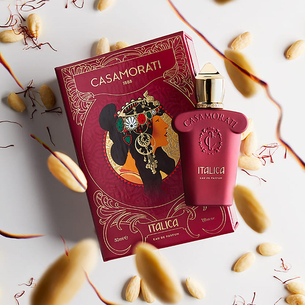 Casamorati Italica perfume bottle and packaging on a decorative background with leaves and nuts.