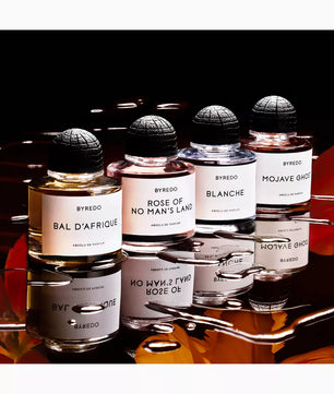 Collection of Byredo perfume bottles on a reflective surface with a dark background