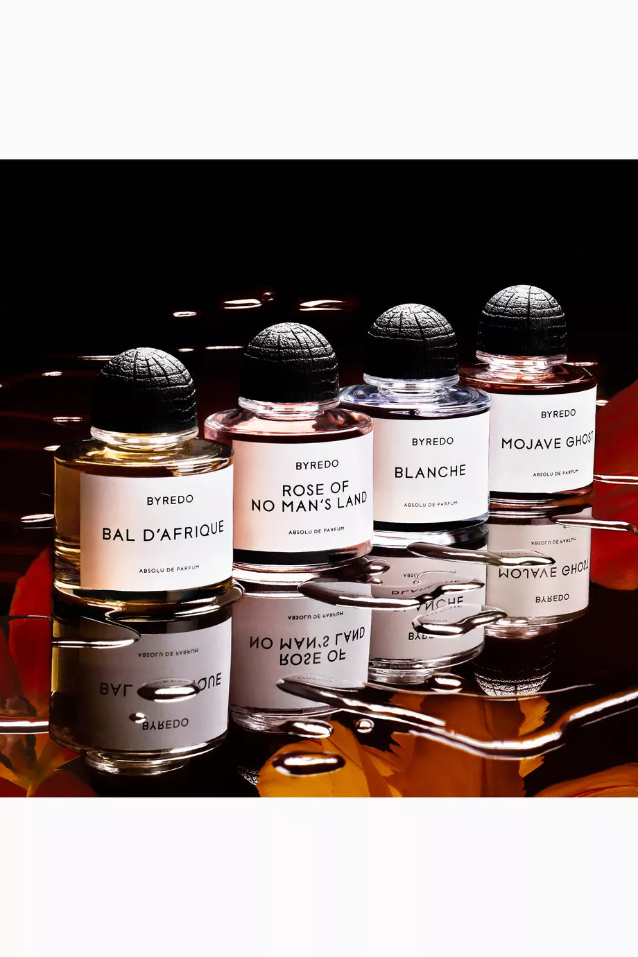 Collection of Byredo perfume bottles on a reflective surface with a dark background