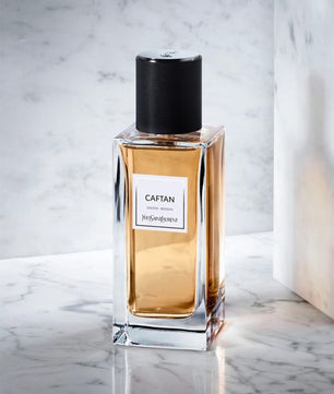 Perfume bottle labeled 'CAFTAN' on a marble surface