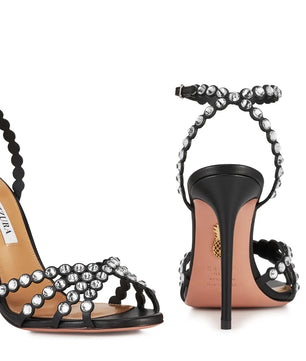Black high-heeled sandals with beaded straps on a white background