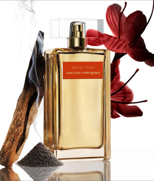 Narciso Rodriguez saffron musc perfume bottle with a red flower and wooden element on a white background