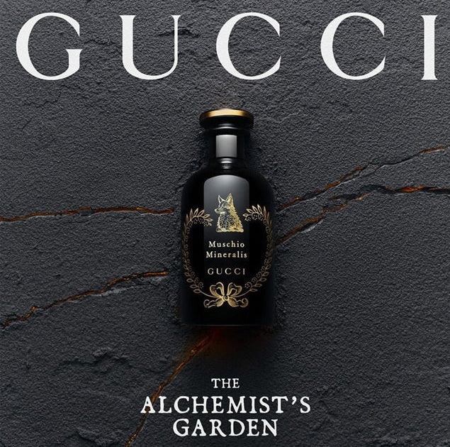 Gucci bottle with 'The Alchemist's Garden' text on a dark textured background
