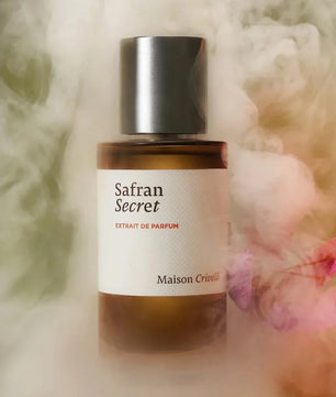 Perfume bottle labeled 'Safran Secret' by Maison Crivelli with a soft, blurred background.