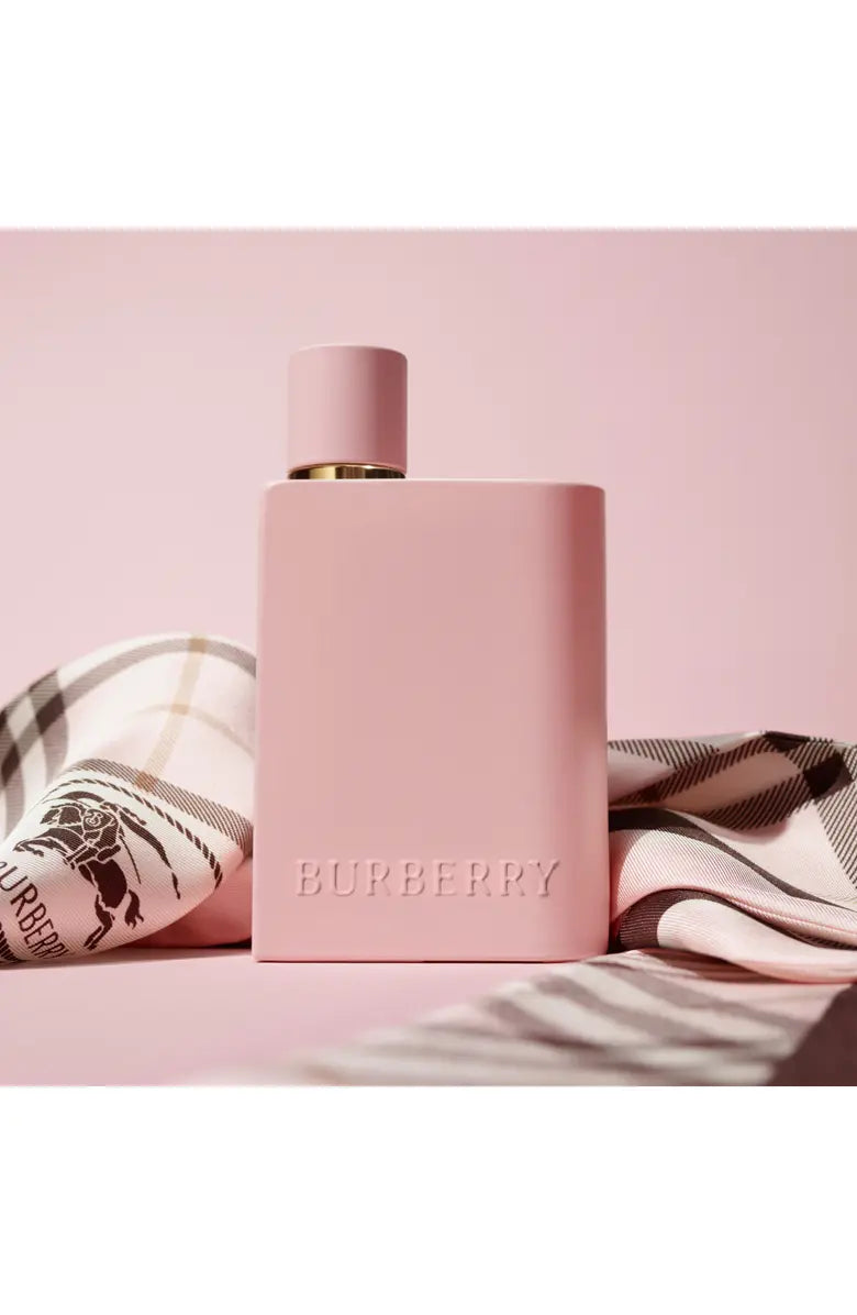 Pink Burberry perfume bottle on a pink background with a checkered cloth.