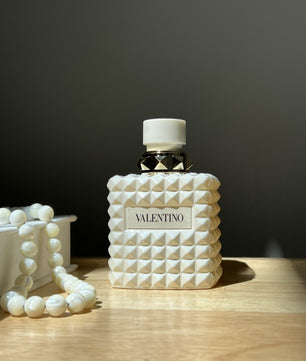 Valentino perfume bottle with textured design on a wooden surface
