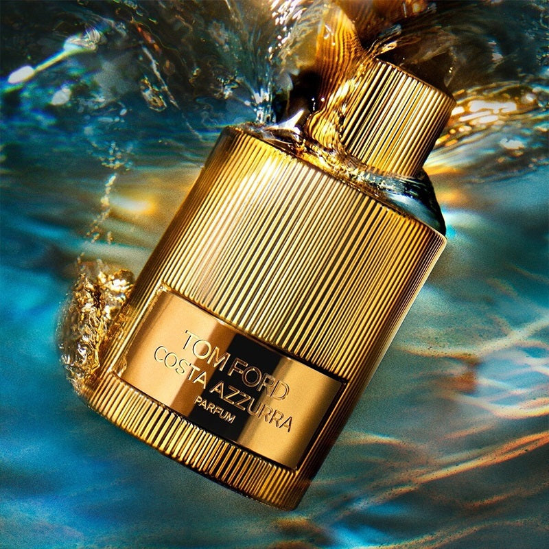 Gold Tom Ford Costa Azzurra parfum bottle with water droplets on a blue background