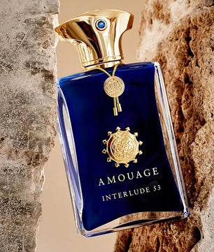 Amouage Interlude 53 perfume bottle with gold cap against a textured stone background