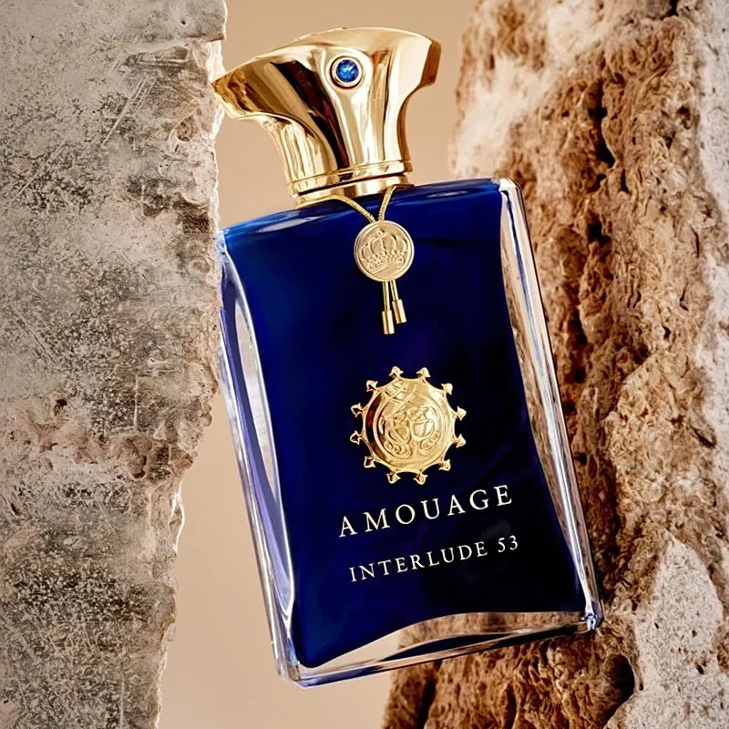 Amouage Interlude 53 perfume bottle with gold cap against a textured stone background