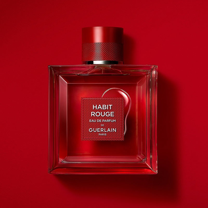 Red Guerlain perfume bottle on a red background
