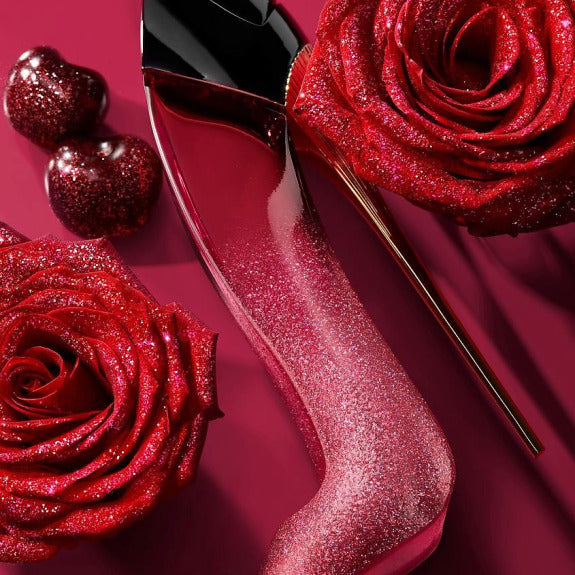 Red glittery nail polish bottle with a rose on a red background