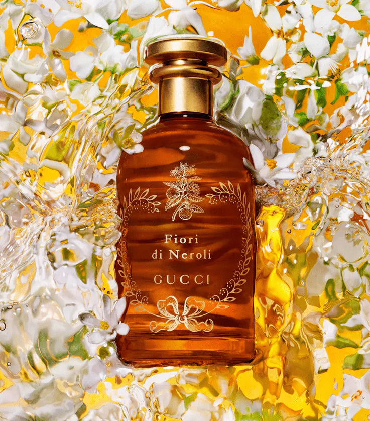 Gucci Fiori di Neroli perfume bottle surrounded by flowers on a yellow background