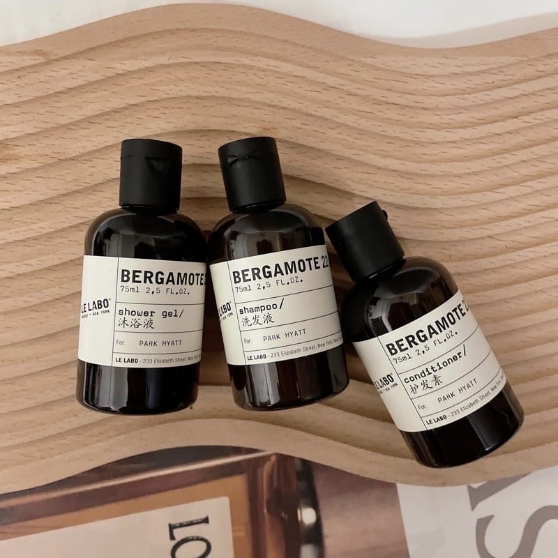 Three bottles of Bergamote products by Le Labo on a wooden surface.