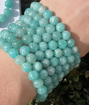 Turquoise beaded bracelet on a wrist with a blurred natural background