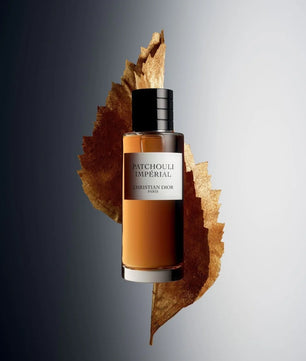Christian Lior Patchouli Imperial perfume bottle on a leaf with a gray background