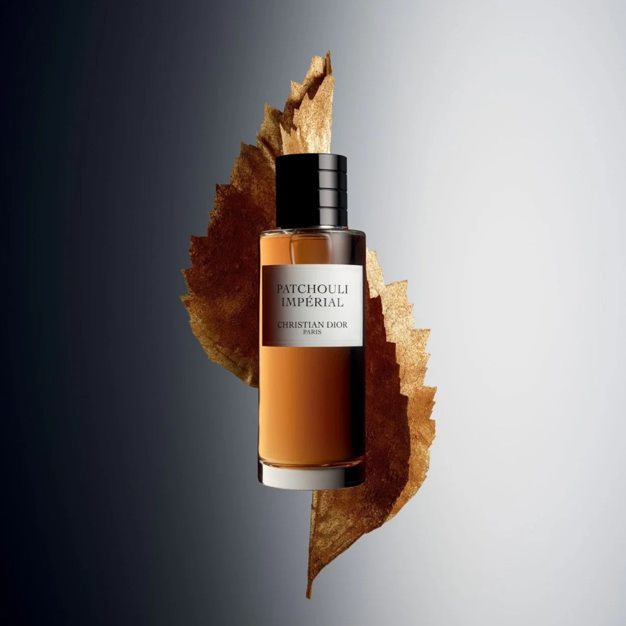Christian Lior Patchouli Imperial perfume bottle on a leaf with a gray background