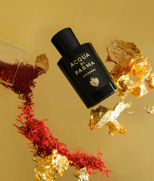 Acqua di Parma perfume bottle with saffron and gold elements on a yellow background