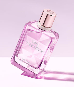 Pink Givenchy perfume bottle labeled 'Very Irresistible' on a light purple background