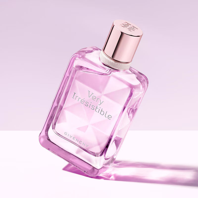 Pink Givenchy perfume bottle labeled 'Very Irresistible' on a light purple background