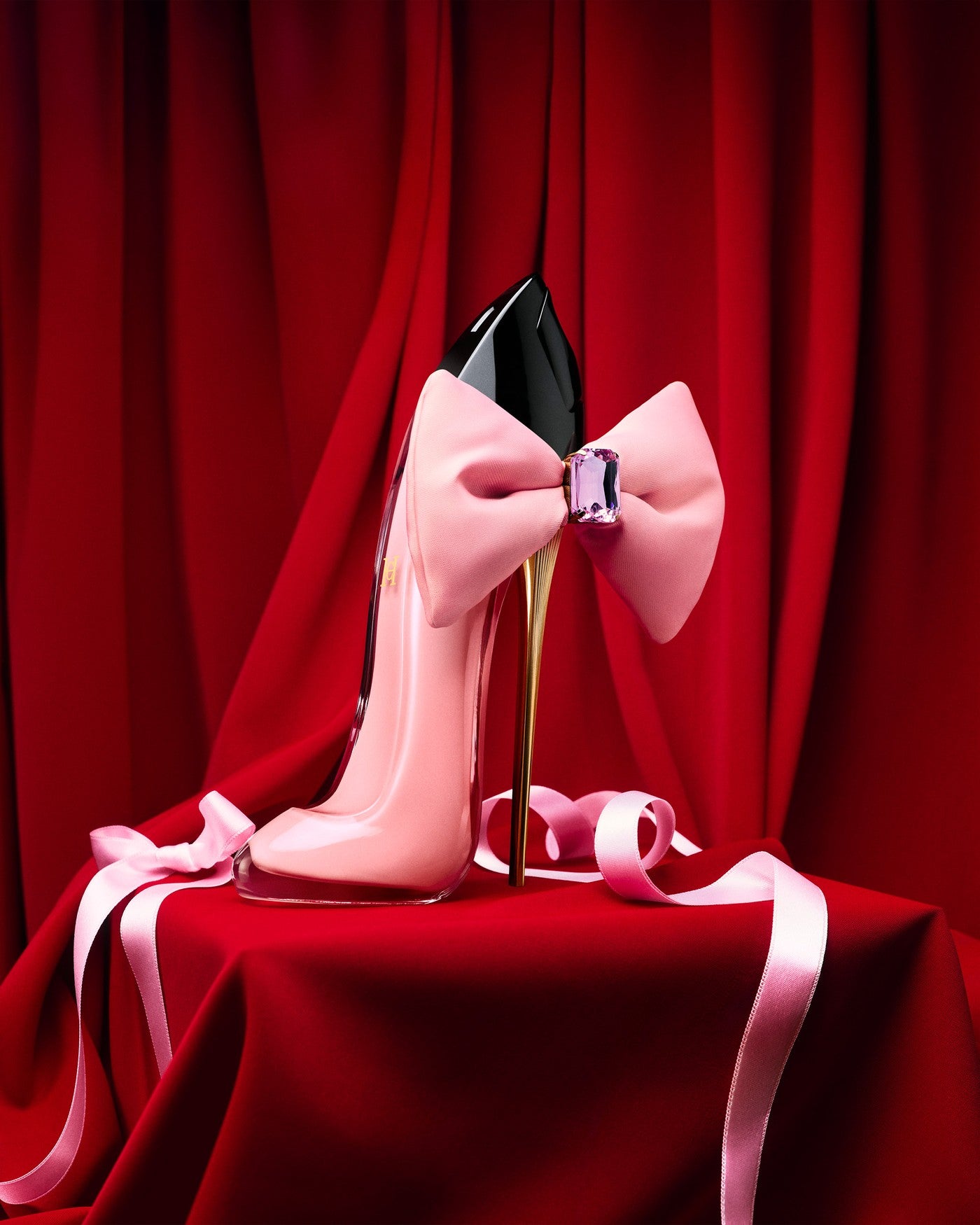 High-heeled shoe with a large pink bow and gemstone on a red background