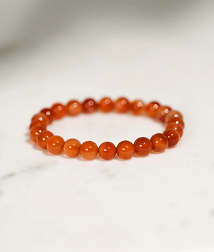 Orange beaded bracelet on a light gray background