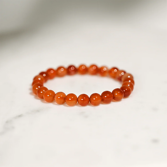 Orange beaded bracelet on a light gray background