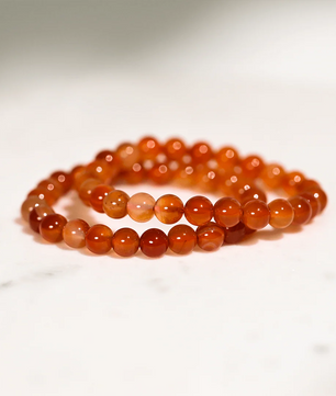 Beaded bracelet made of orange beads on a white background