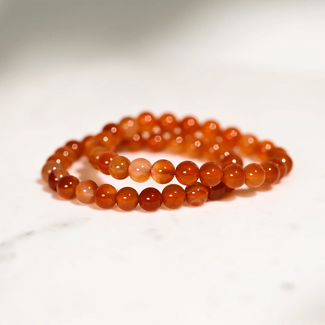 Beaded bracelet made of orange beads on a white background
