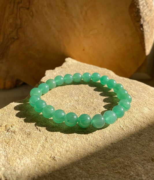 Green beaded bracelet on a textured stone surface