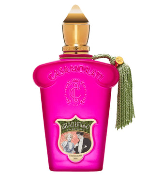 Pink Casamorati perfume bottle with gold cap and green tassel on a white background