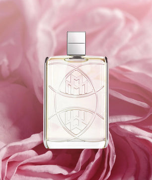 Perfume bottle with decorative design on a pink fabric background