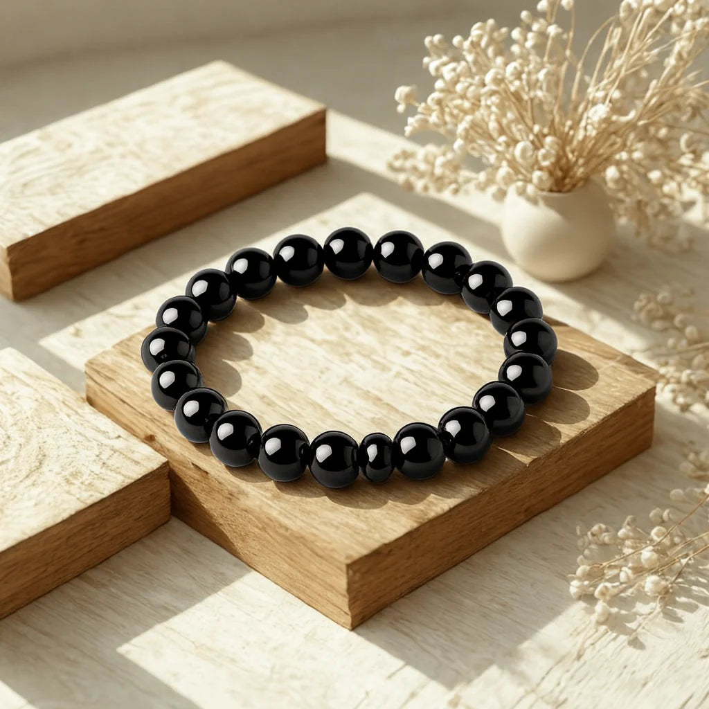 Black beaded bracelet on a wooden surface with decorative elements
