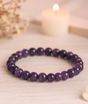Purple beaded bracelet on a light wooden surface with a soft focus background