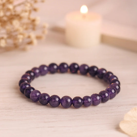 Purple beaded bracelet on a light wooden surface with a soft focus background