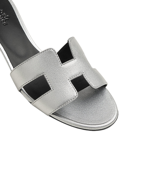 Silver sandal with black straps on a white background
