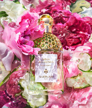 Perfume bottle with gold cap on a floral and cucumber background