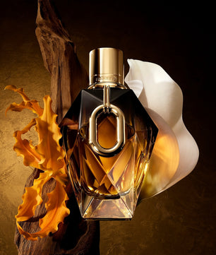 Perfume bottle with gold cap and clear body on a textured brown background